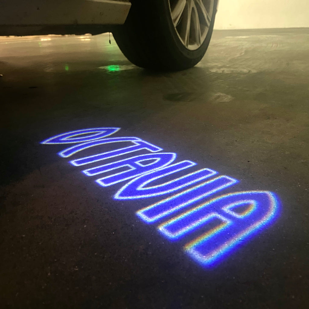 LUCI PROIETTORI LOGO SKODA Nr.102 (quantità 1 = 2 Logo Film / 2 luci porta)